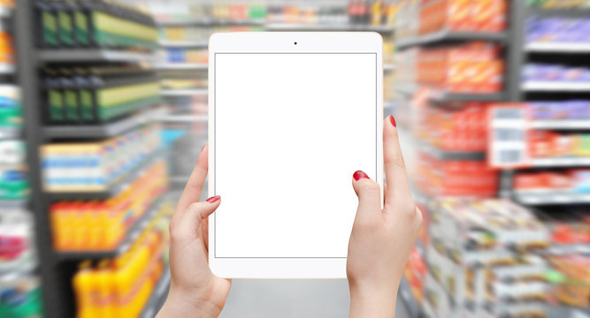 Girl holding tablet with isolated screen in supermarket