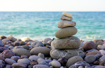 Fototapeta na wymiar Stack of pebbles on beach against sea