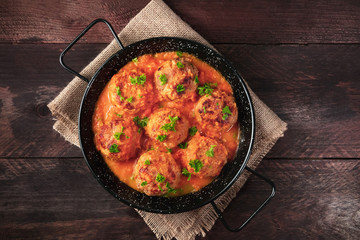 Pan of meatballs in tomato sauce, overhead photo with copyspace