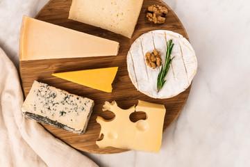 Selection of cheeses on white marble table with copyspace