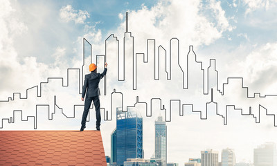 Man architect draw silhouette of modern city on blue sky. Mixed 