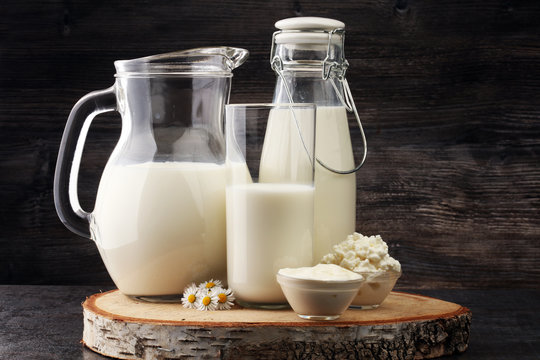milk products - tasty healthy dairy products on a table sour cream in a glass bowl, cottage cheese and milk jar