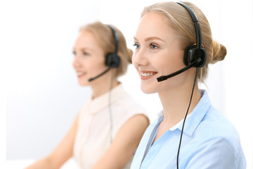 Call center. Focus on beautiful blonde woman in headset