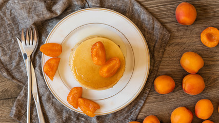 Top view stack of homemade american pancakes served with honey and apricots on wooden background