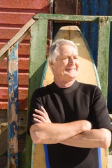 Man with surfboard standing against hurt at beach