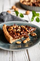 Delicious chocolate tart with walnut, peanut, dried cranberry and raisins