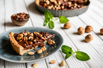 Delicious chocolate tart with walnut, peanut, dried cranberry and raisins