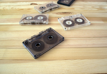 Several audio cassettes lie in a row on a wooden background