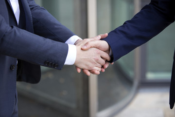 two men in suits shaking hands