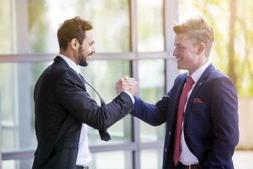 two businessmen smiling and shaking hands