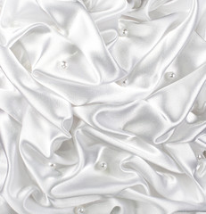 background of white brocade and silvet satin with pearl and waves tissue occupying the entire...