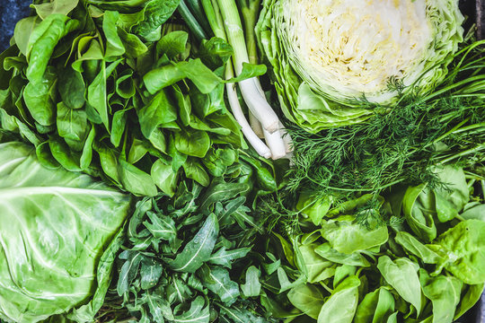 Background of a lot of fresh green different vegetables and herbs, top view, close-up. The concept of healthy, proper nutrition, diet, detox, cleansing