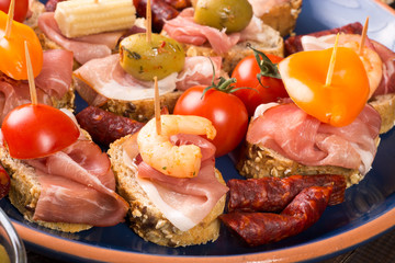 Canapes with ham and olives on plate
