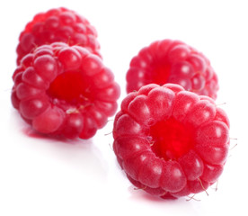 four Raspberry sweet ripe bright red berries isolated on a white background