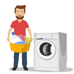 Unhappy young man standing next to washing machine with basin filled with dirty clothes