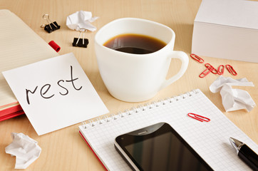 Office desk with notepads, phone, paper for notes and  cup of coffee