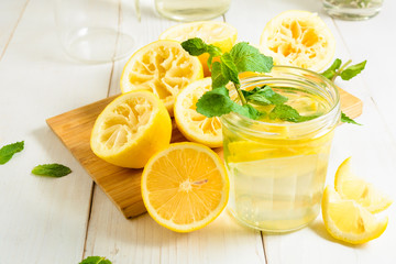 Lemonade with mint and squeezed lemons on board