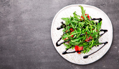  Salad with arugula , Fresh Cherry Tomatoes with Balsamic dressing and Olive oil.Food or Healthy diet concept.Super Food.Vegetarian.Top View.Copy space for Text.