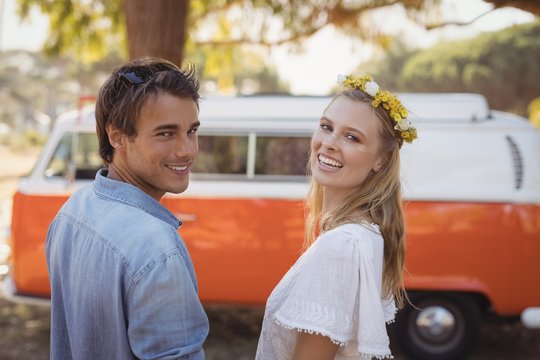 Portrait of smiling couple against van