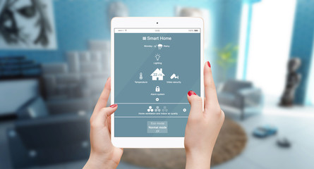 Woman controling smart house system with app on her tablet