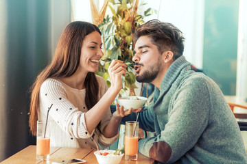 Happy couple at restaurant eating breakfast