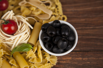 Dry pasta with ingredients on a old wood
