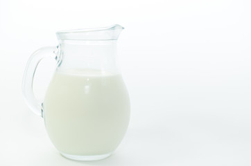 Fresh cow milk in a jar on a light background.