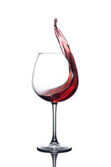 Splash of red wine in a glass on a white background with reflection