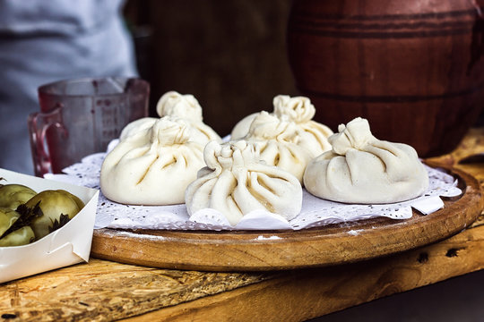 National Georgian cuisine Khinkali wooden background Cook prepares khinkali kitchen Top view raw meat dough dish uncooked Street food booth selling Chinese specialty Steamed Dumplings Process cooking