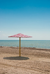 The parasol on empty sandy beach