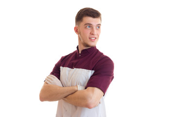 handsome young guy in two-tone t-shirt smiles hands clasped on his chest and looks away