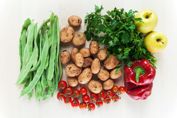 Group of fresh vegetables on a light wooden kitchen table