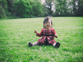 baby girl playing meadow on sunny day