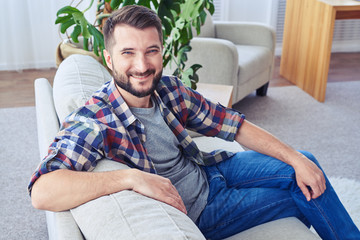 Obraz premium Good-looking male with blue eyes relaxing on fashionable sofa