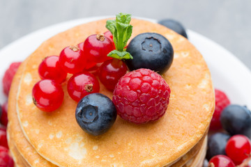 Stack of pancakes with blueberry and fresh berry.