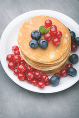 Stack of pancakes with blueberry and fresh berry.