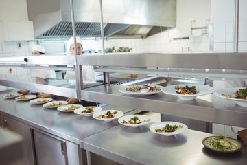 Chefs preparing food at order station