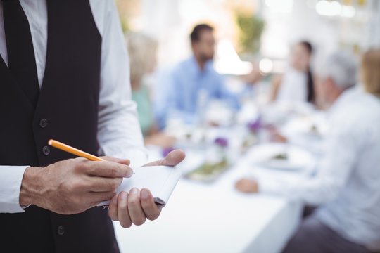 Waiter writing order on notepad
