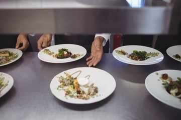 Male chef keeping appetizer plate ready on the order station