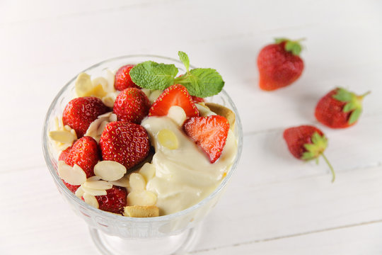 Strawberry dessert with yogurt, almond shavings and mint