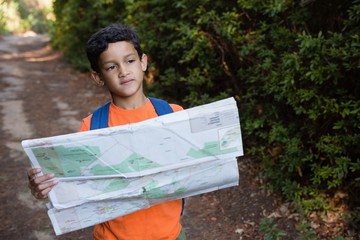 Boy holding the map and looking at the distance