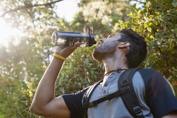 Thirsty man drinking water in the forest