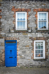 Fototapeta na wymiar Blue doors and windows of an old home