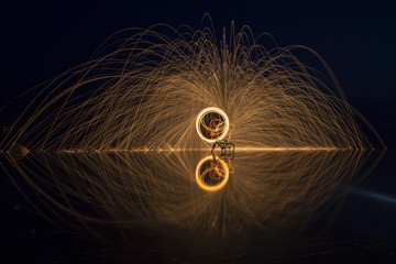 Sparks Flying off Burning Steel Wool. Burning steel wool fireworks water reflection 