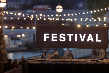 Festival Sign with blurred string lights in the background