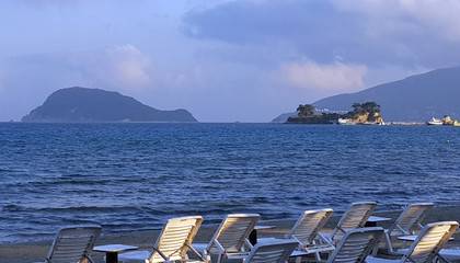 Beach chairs in Laganas beach with the Marathonisi Island and Cameo island