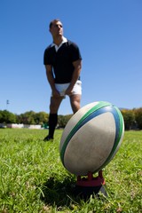 rugby ball against player on grassy field 