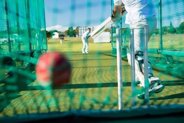Low section of spoertsman playing cricket at field