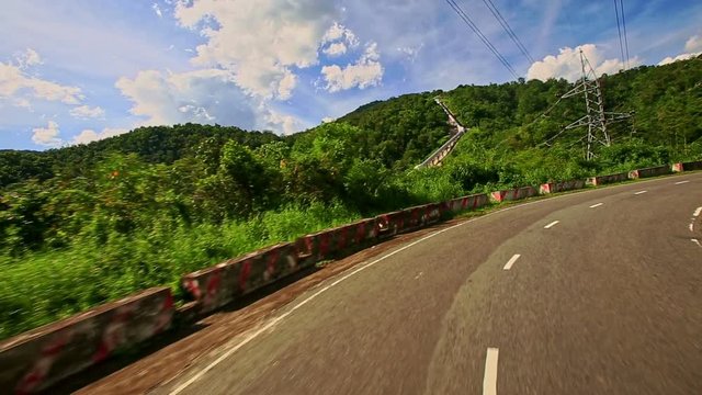 Camera Moves along Country Curvy Road among Hilly Landscape