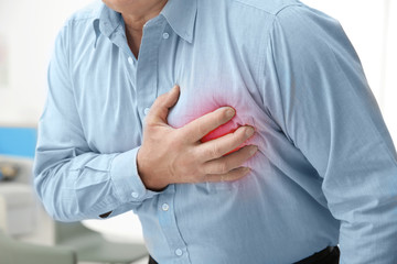 Man with chest pain suffering from heart attack in office